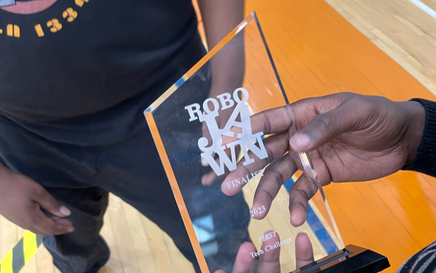 A student proudly holds their 2nd place trophy. 