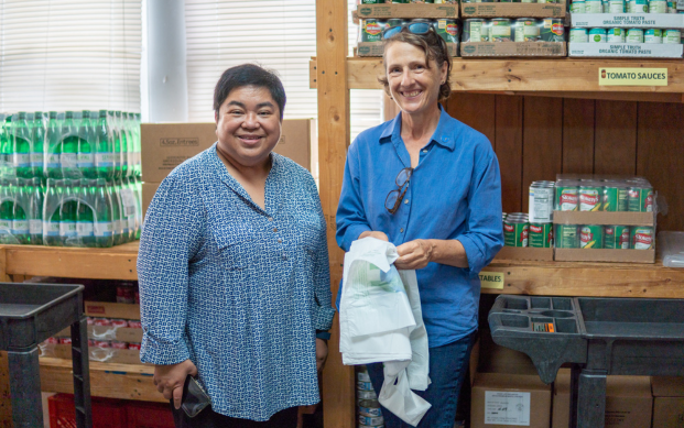 Terry Guerra, community development (right) shares a smile inside the food panty. manager