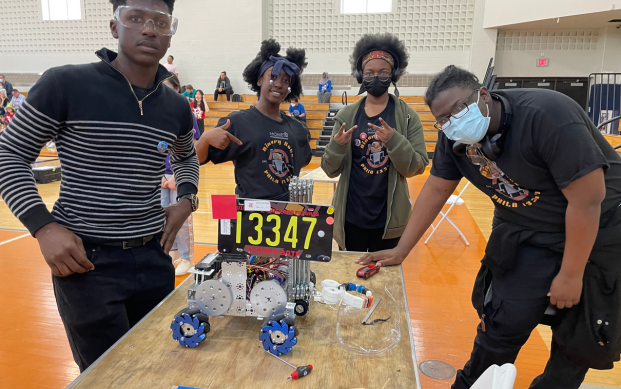 Students pose with the robot they built together. 