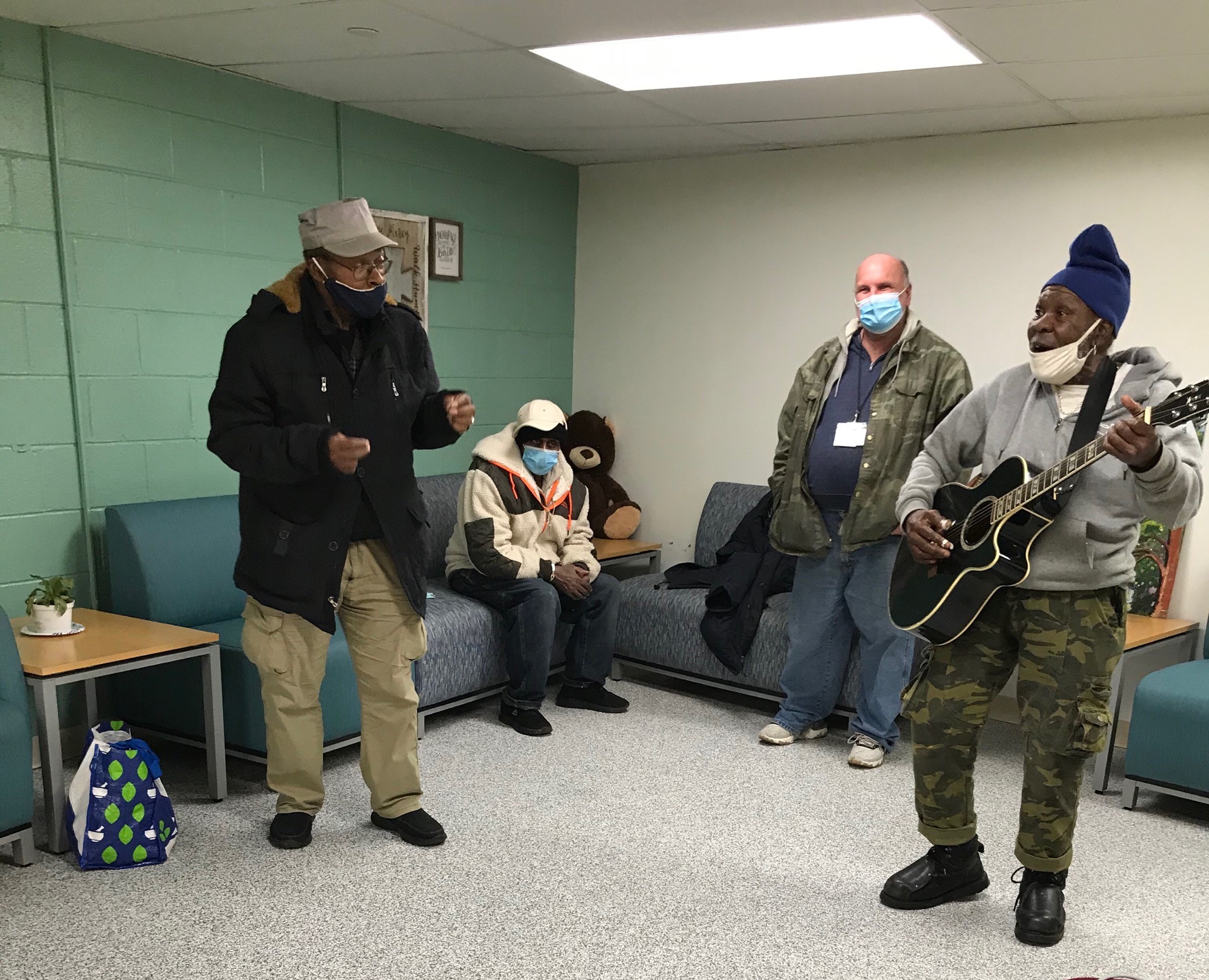 Mr. John playing his guitar Lucille to members of the Living Room in the Hub of Hope at Suburban Station.