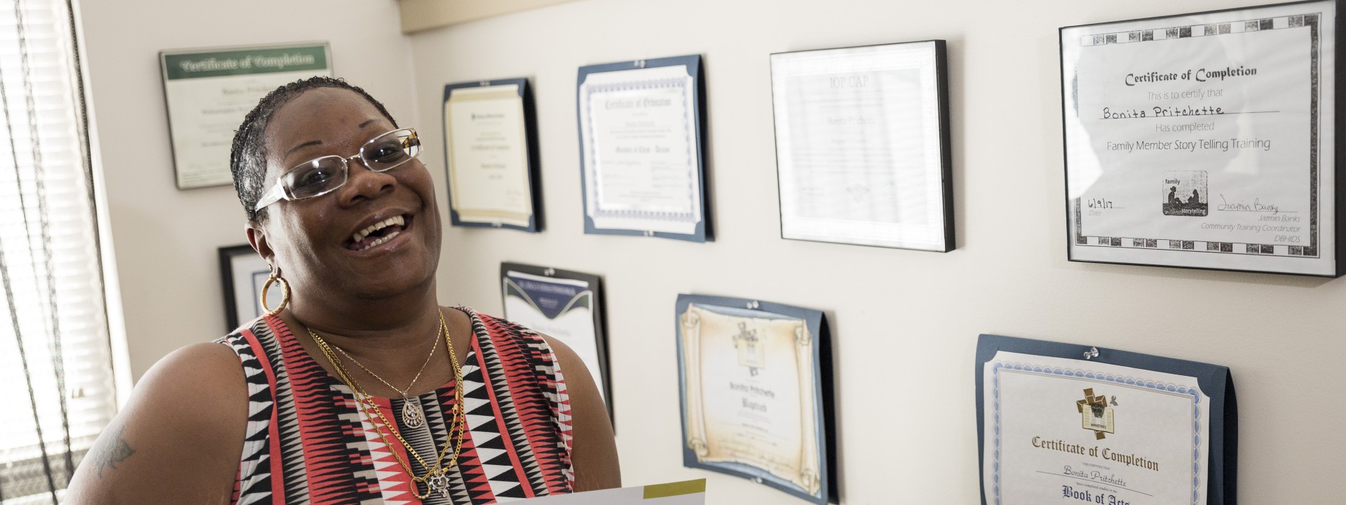 Project HOME resident smiling and holding a certificate