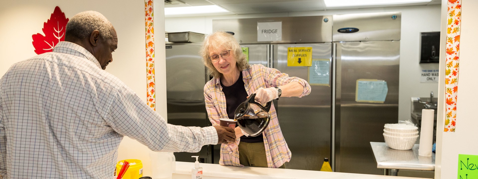 A volunteer serving coffee at the Hub of Hope