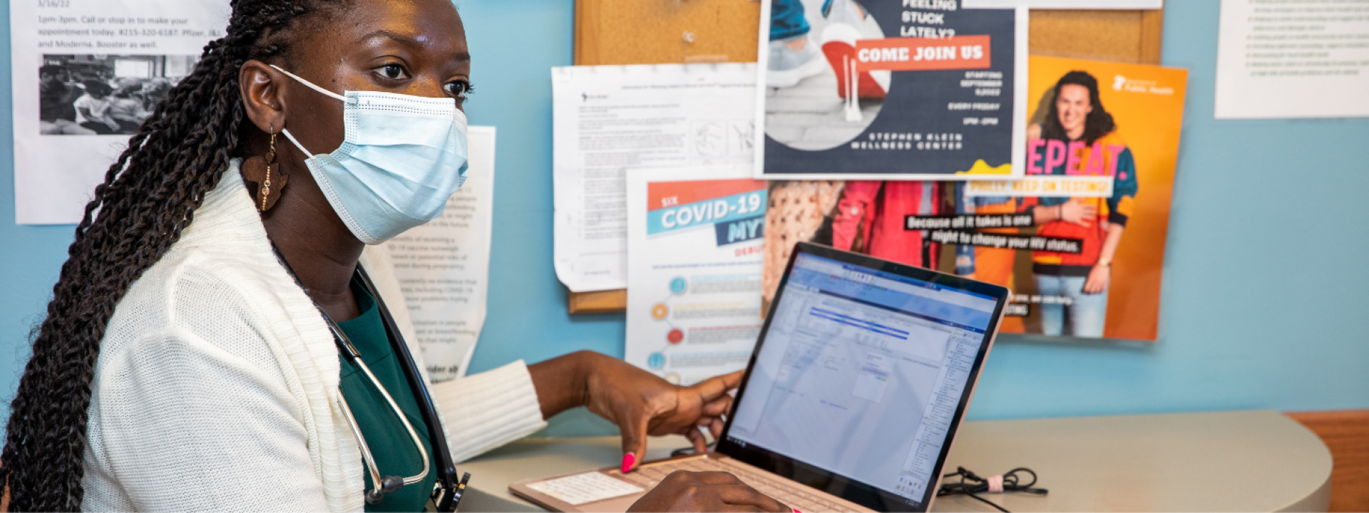 Doctor reviews patient records on a laptop.