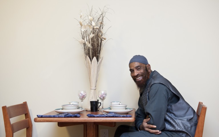 Project HOME resident sitting at dining table in his apartment