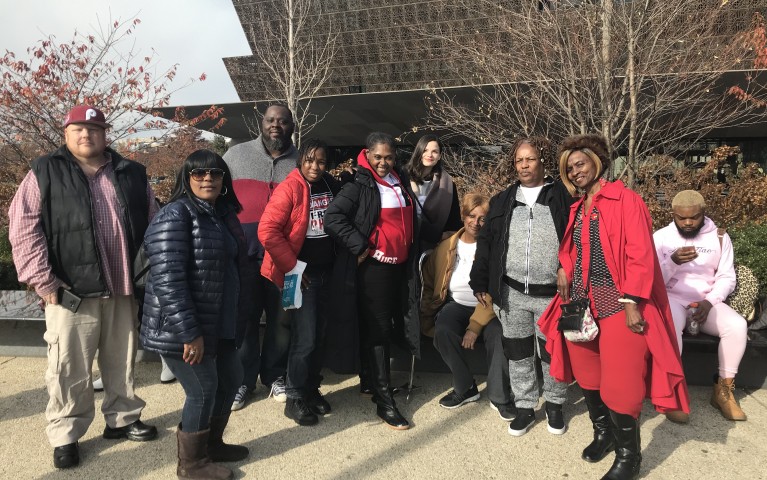 A number of people standing in front of the African-American Museum in Washington DC