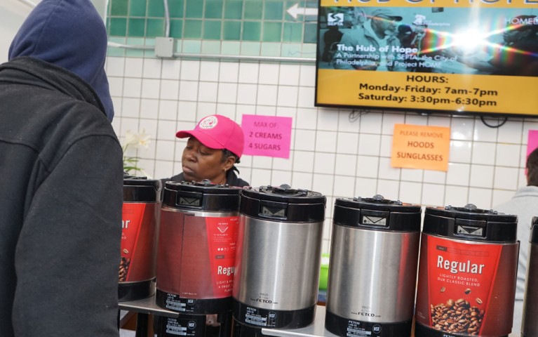 A volunteer serving coffee at the Hub of Hope