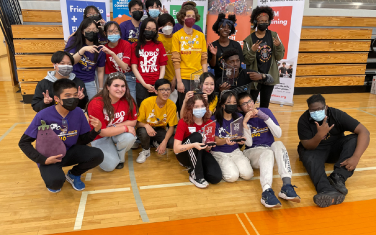 The teen program's 'BinaryBots' pose with their competition trophy.