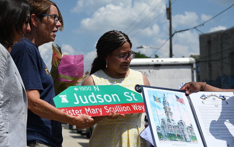 Sister Mary Scullion displays the street sign with her name.