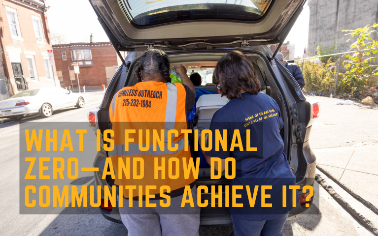 Two outreach workers getting water from the back of a van for people outside.