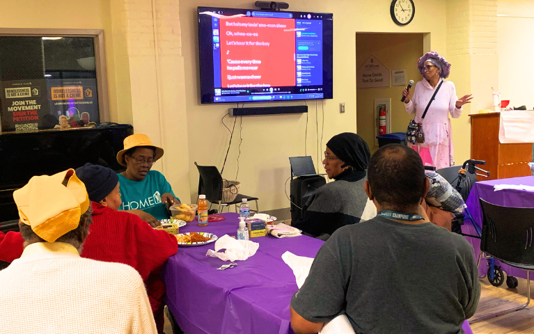 Project HOME residents watch a karaoke performance