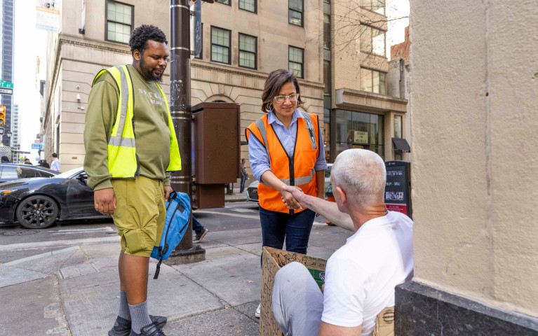 A Project HOME outreach workers speaking with a person experiencing homelessness