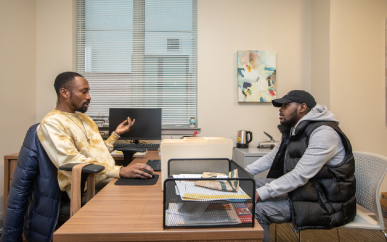 Two men talking from across a desk