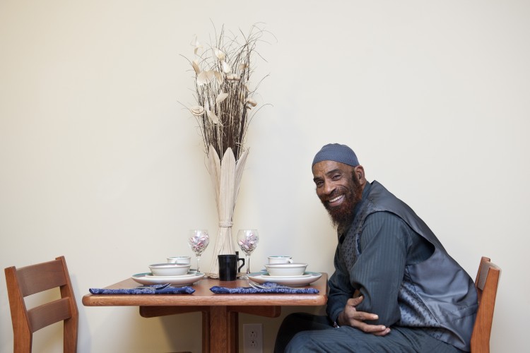 Project HOME resident sitting at dining table in his apartment