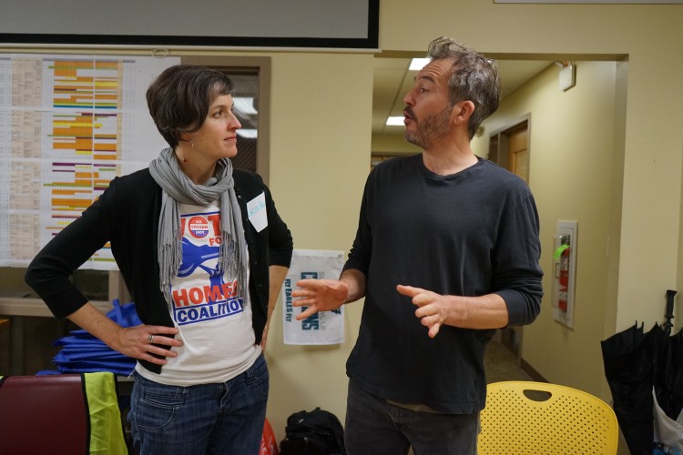 Vote for Homes Coalition members talk during a voter registration drive.