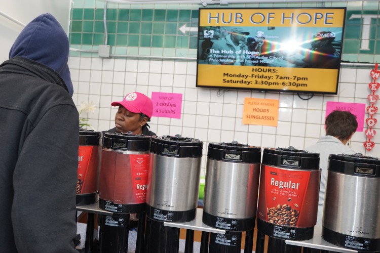 A volunteer serving coffee at the Hub of Hope