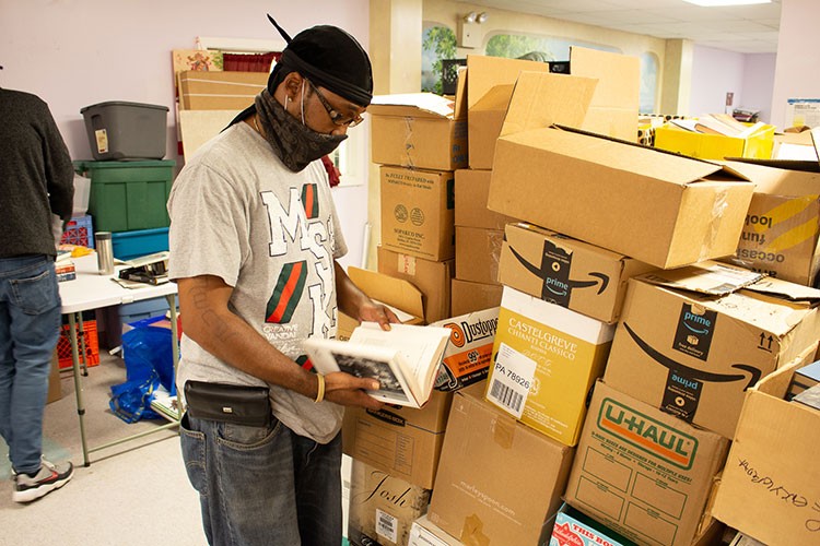 A Project HOME staffer sorts books