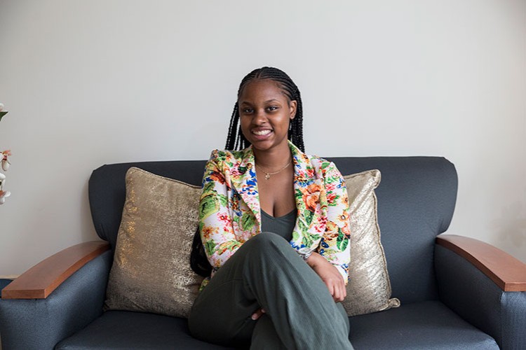 Former Project HOME Young Adult Resident sitting on a couch