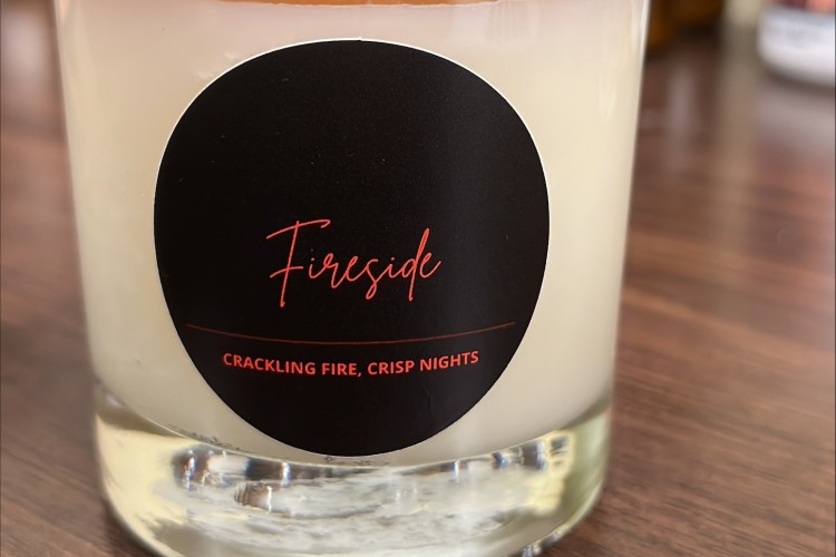 A candle labeled Fireside on a table.