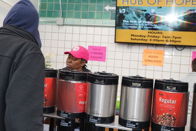 A volunteer serving coffee at the Hub of Hope