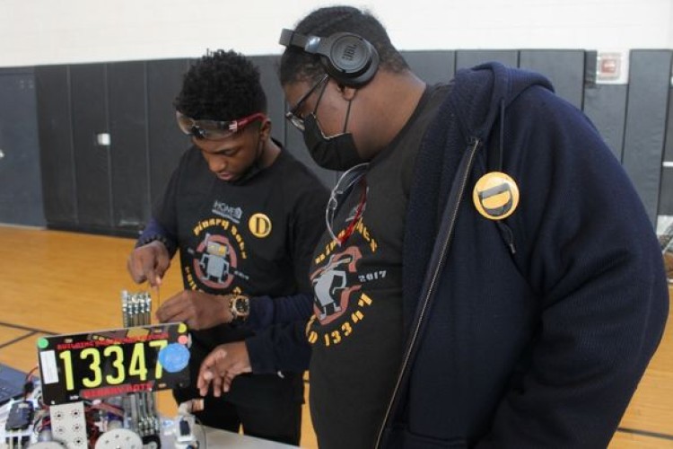 Two students working on a robot 