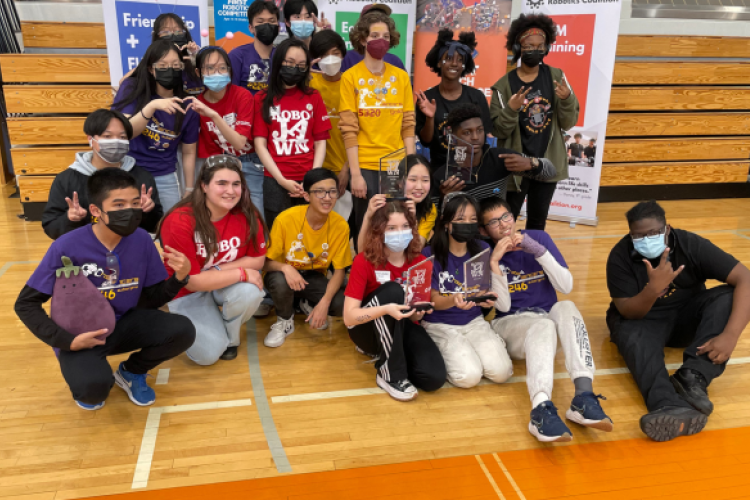 The teen program's 'BinaryBots' pose with their competition trophy.