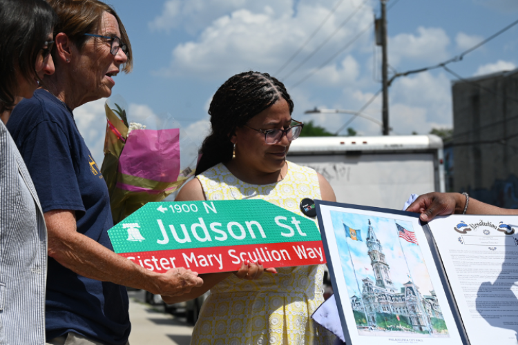 Sister Mary Scullion displays the street sign with her name.