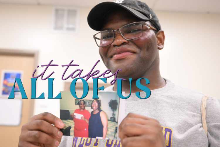 A smiling man holds up a picture showing two women