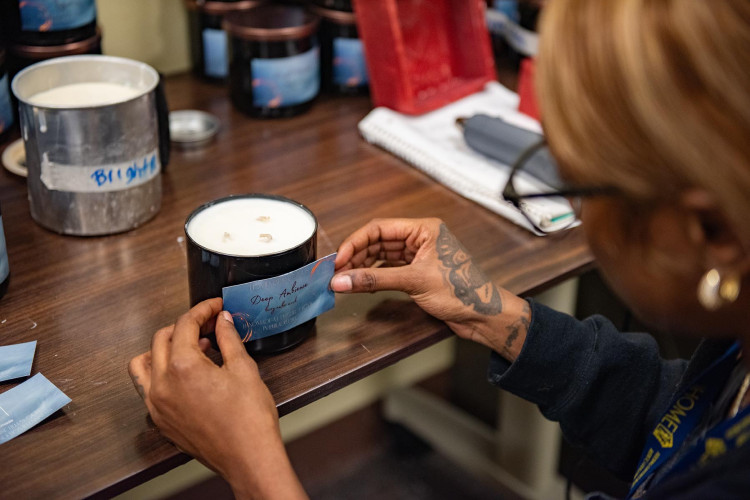 A woman applying a label to a candle