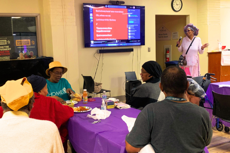 Project HOME residents watch a karaoke performance