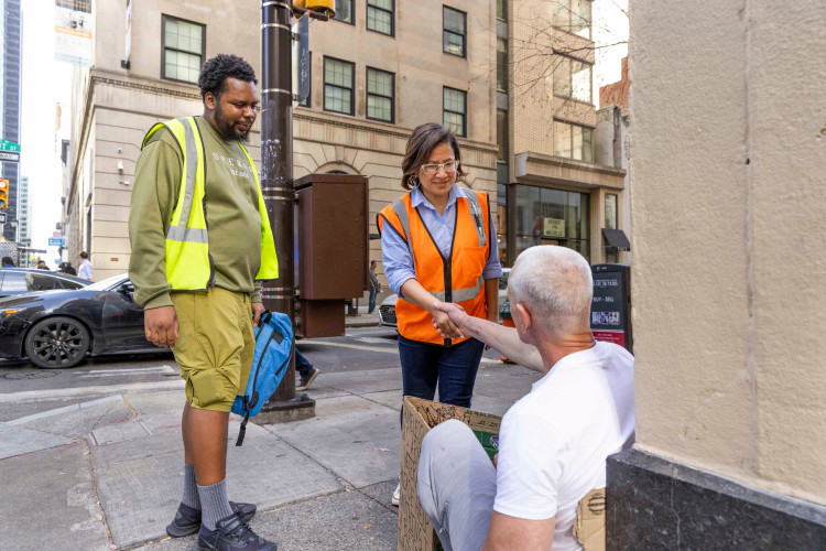 A Project HOME outreach workers speaking with a person experiencing homelessness