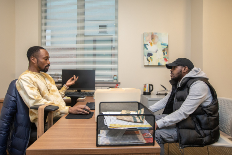 Two men talking from across a desk